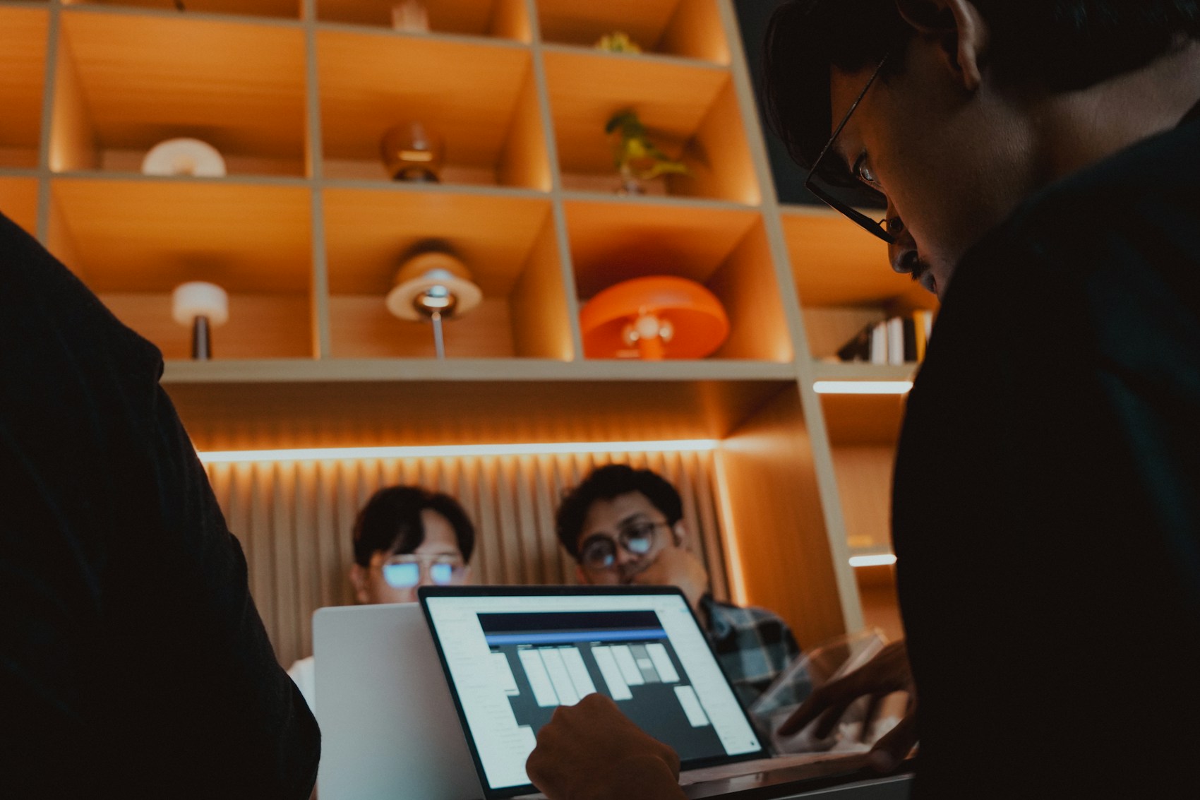 Designers discussing a digital layout in a warm workspace